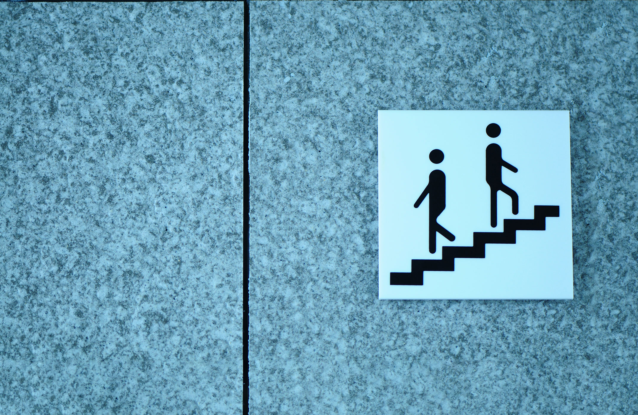 Schild mit zwei Personen auf einer Granitplatte aufgebracht.