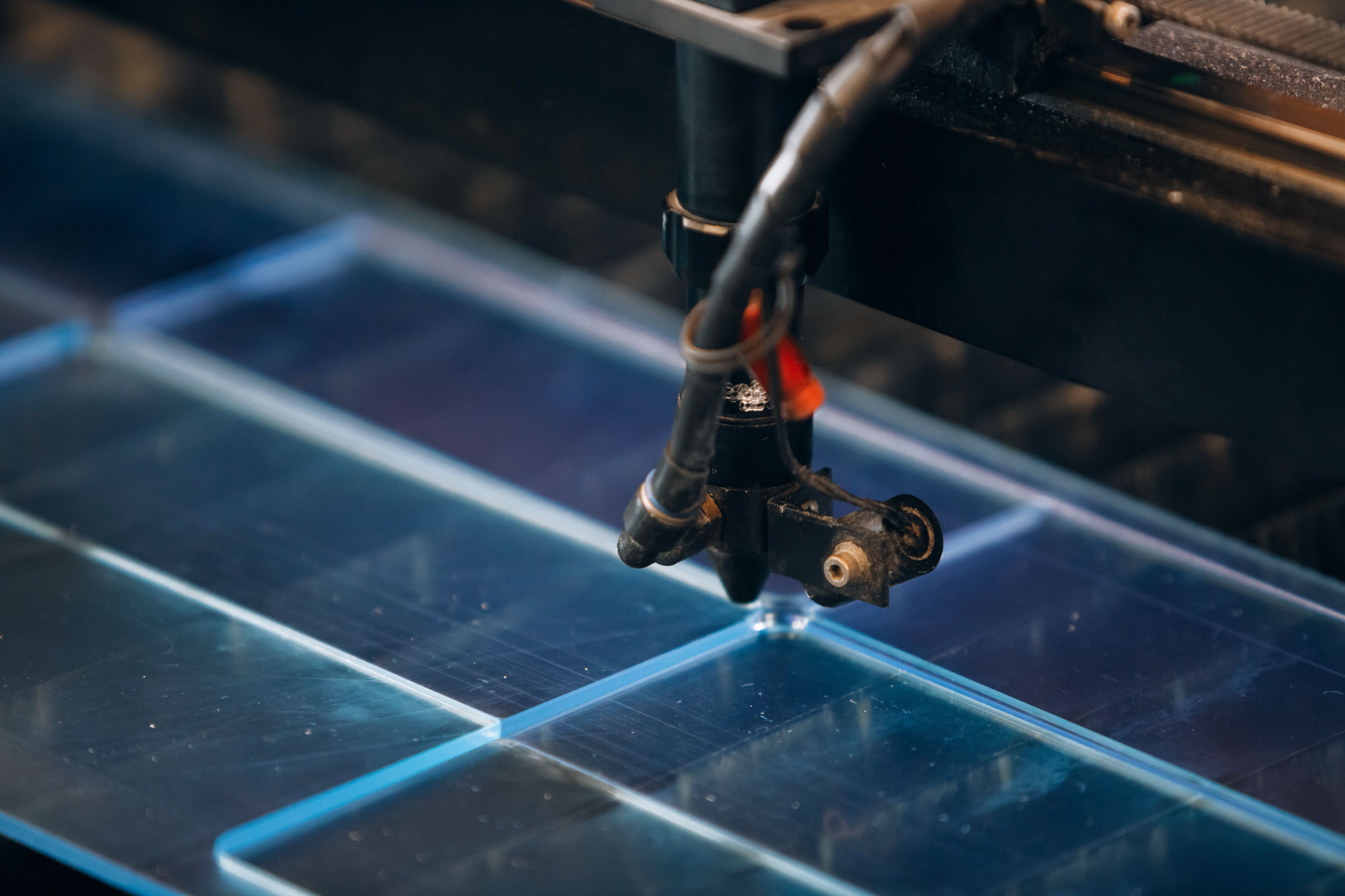 Ein Laser schneidet eine Acrylplatte in 3D Buchstaben 